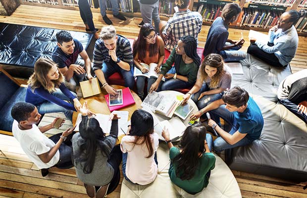 Grupo de gente debatiendo en biblioteca